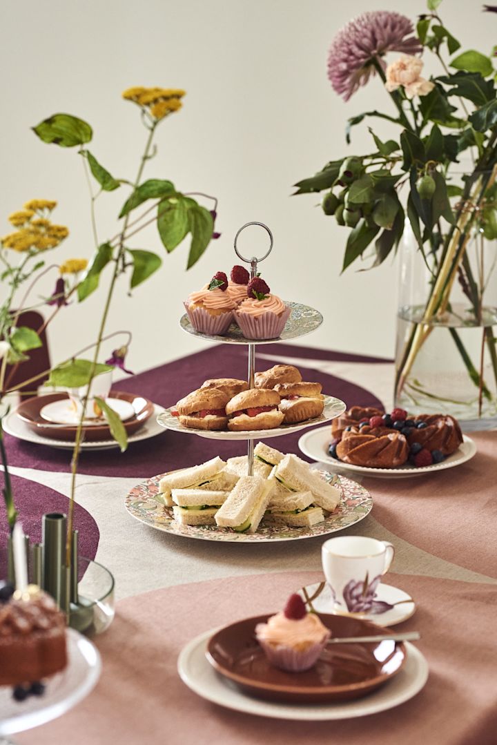 Her kan du se et flot dækket bord med et kagestel i flere etager med muffins og andre lækkerier.