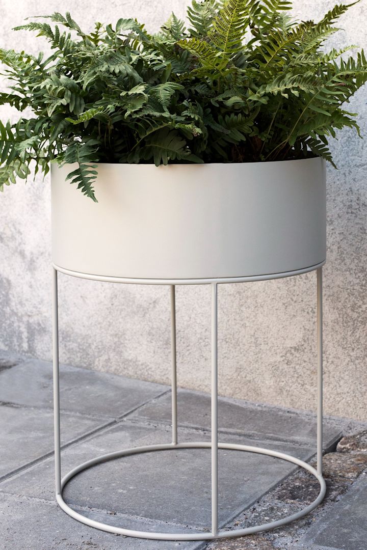 Fra Ferm Living kan du købe en rund plantekasse, som er en stor rund metalpotte med stativ. Den store potte er perfekt til større planter, men fungerer også godt til at have en mindre dyrkning i.