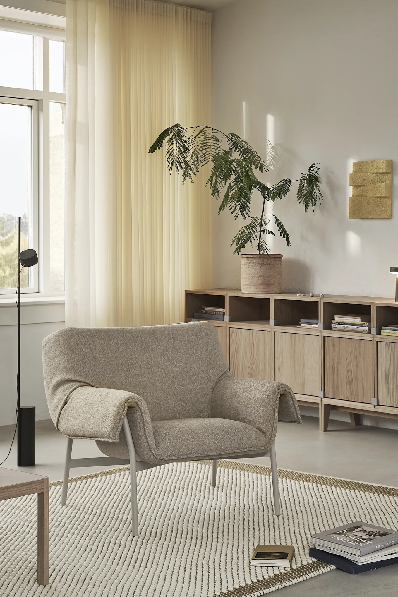 Greige er på vej tilbage i indretningstrenderne i 2025, her kan du se lænestolen Wrap from Muuto i en grå beige nuance.