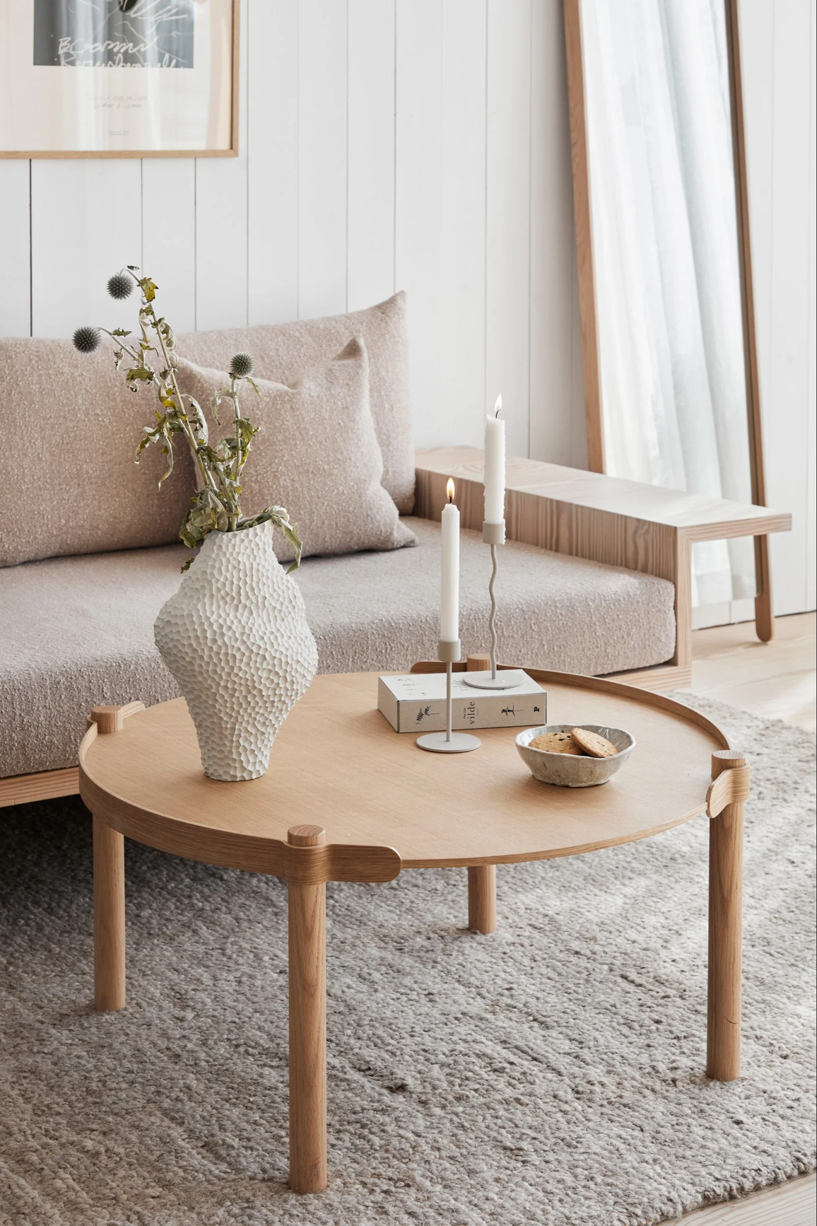 En cremefarvet skandinavisk stue med produkter fra Cooee Design som f.eks. Woody kaffebord, Isla vasen og Curve lysestagen.