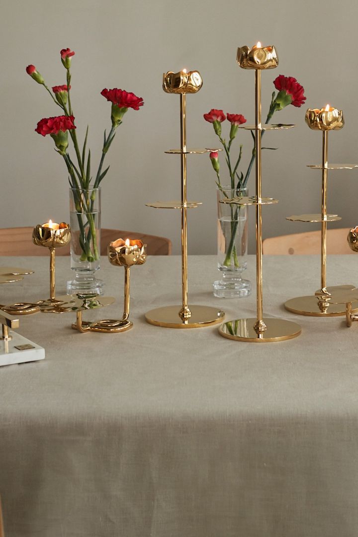 Giv en lysestage fra Hilkes Ninfea-kollektion, som her er vist med røde blomster på bordet, og som især er kendetegnet ved deres åkandeform.