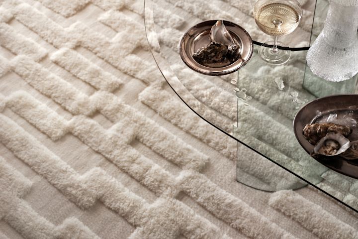 Et hvidt tæppe med et tekstureret mønster fra svenske design mærke Tinted Objects. 