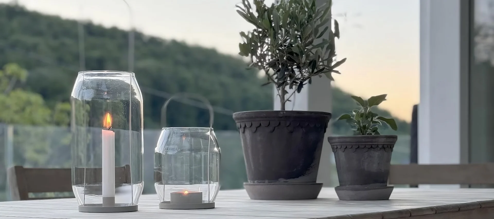 To Københavner urtepotter fra Bergs Potter står på et bord ved siden af to Ernst-lanterner på @zuhauseligs terrasse.