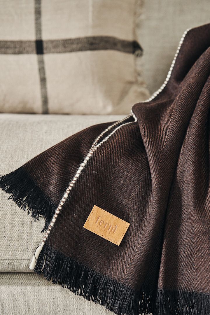 Herringbone plaiden i mørkebrun fra Ferm Living med det smukke mærke i fokus.
