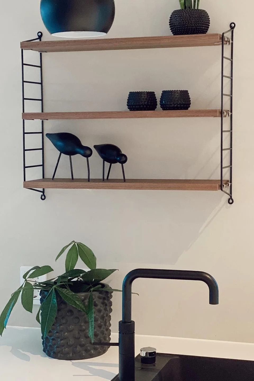 Selv isolerede sorte elementer, som her i form af en string pocket-hylde i @interiorbysunnivas køkken, giver dit hjem en industriel stil.